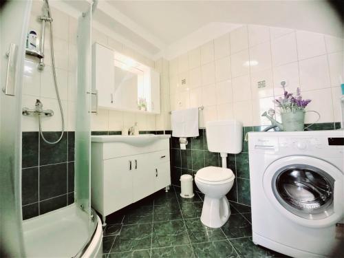 a bathroom with a toilet and a sink and a washing machine at Apartment Megi in Supetar historical core in Supetar