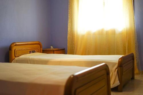 two beds in a room with a window at Traditional cozy residence in Lafkos, Pelion in Lafkos