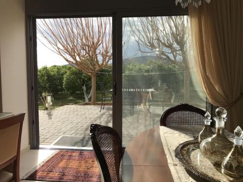 d'une salle à manger avec une table, des chaises et une porte coulissante en verre. dans l'établissement Villa apartment with private garden near the beach, à Drepano