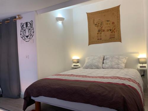 une chambre avec un grand lit avec deux lampes dans l'établissement Duplex Raphael- Wi-fi et parking privé, à Toulon