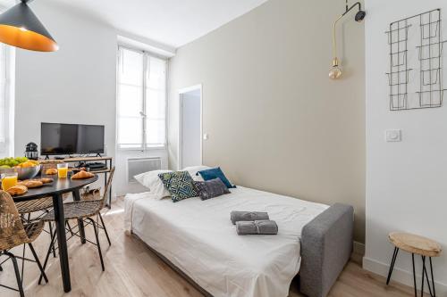 a bedroom with a bed and a table with a dining room at HOME: Les richesses de Marseille à vos pieds! in Marseille