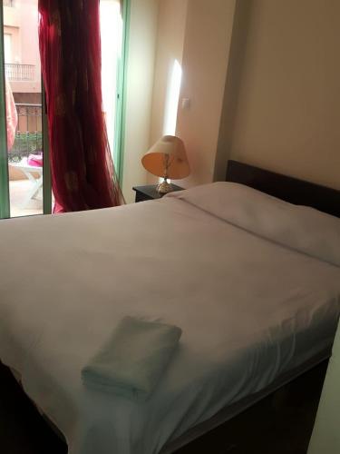 1 dormitorio con cama blanca y ventana en Propre appartement à loué pour les familles en Marrakech