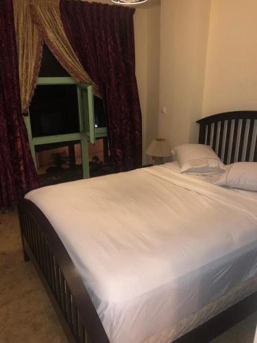 Propre appartement à loué pour les familles في مراكش: سرير أبيض كبير في غرفة نوم مع تلفزيون