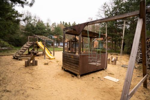 a playground with two swings and a slide at Penzion U hájovny u pískoven - Vlkov in Vlkov