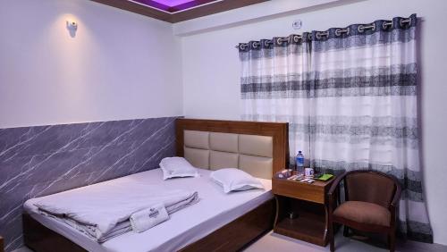 a small bedroom with a bed and a desk with a chair at Hotel Cox Rotana in Cox's Bazar
