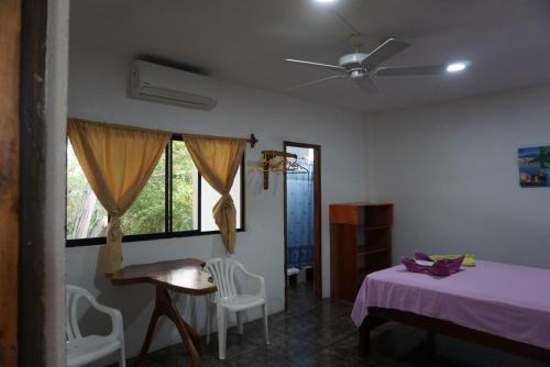 a bedroom with a bed and a ceiling fan at Hostal Suiza in Puerto Baquerizo Moreno