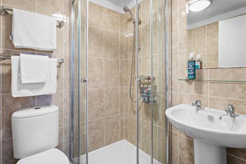 a bathroom with a shower and a toilet and a sink at Kethla House in Torquay