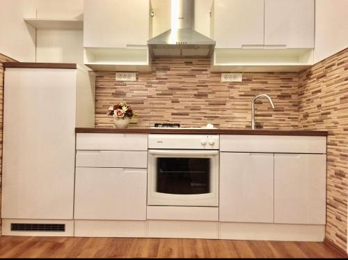 a kitchen with white cabinets and a sink at Holiday house "Mimoza" 2 massage pools in Otočac