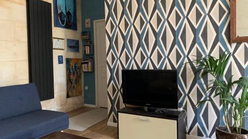 un soggiorno con TV e parete di Maison entière - 2 chambres doubles a Lormont