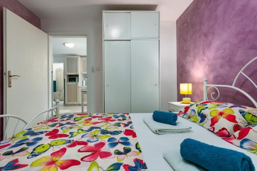 a bedroom with a bed with a floral bedspread at Apartman Nik in Nova Vas