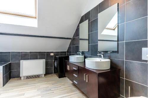 La salle de bains est pourvue de 2 lavabos et d'un miroir. dans l'établissement Le 48-GregIMMO-Appart'Hôtel, à Montbéliard