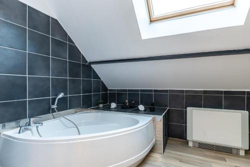 a bathroom with a white tub in a room at Le 48-GregIMMO-Appart'Hôtel in Montbéliard