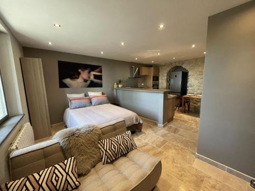 Cet appartement comprend une chambre avec deux lits et un canapé ainsi qu'une cuisine. dans l'établissement LA TRUFFIERE DE SEGURET, à Séguret