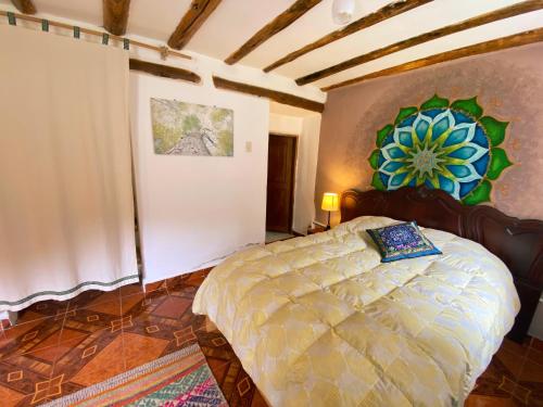 a bedroom with a bed and a painting on the wall at Sonqo Andino Hospedaje Medicina - La Rinconada in Pisac