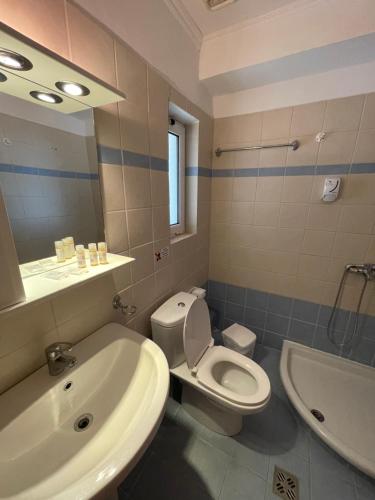 uma casa de banho com um WC, um lavatório e uma banheira em Zenstay Hotel em Áyios Nikólaos Nirás