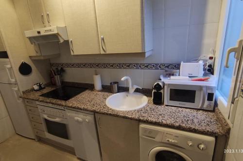 una piccola cucina con lavandino e forno a microonde di Lovely apartment in Madrid center (Chueca) a Madrid