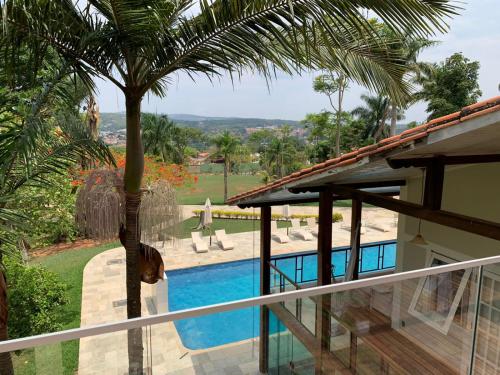 a house with a swimming pool and a palm tree at POUSADA BELA VISTA in Pirenópolis