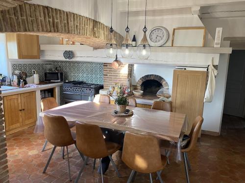 LarnasにあるVilla Masada location saisonnière Ardèche-Provençaleのキッチン(テーブル、椅子、暖炉付)