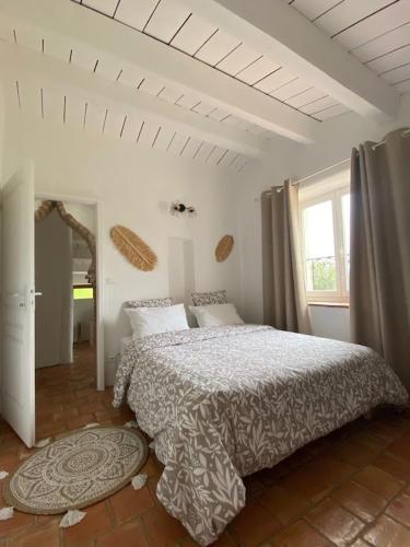 une chambre avec un lit et une grande fenêtre dans l'établissement Villa Masada location saisonnière Ardèche-Provençale, à Larnas