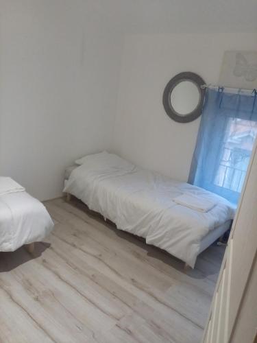 deux lits dans une chambre avec parquet dans l'établissement Au p'tit bonheur, à Saint-Rambert-dʼAlbon