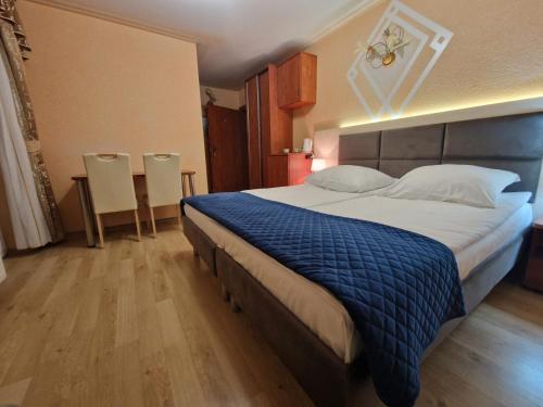 a bedroom with a large bed with a blue blanket at Villa Dora in Mielno