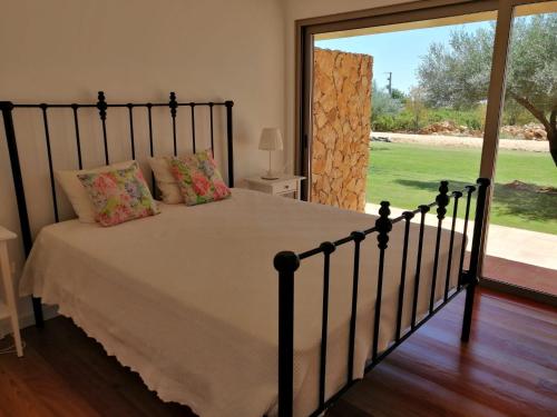 a bedroom with a bed and a large window at Casa do Cabeçudo in Faro