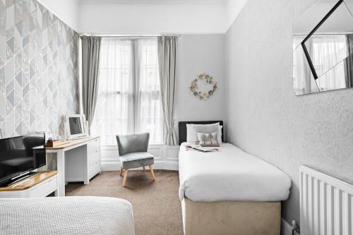 - une chambre avec un lit, un bureau et une chaise dans l'établissement Kethla House, à Torquay