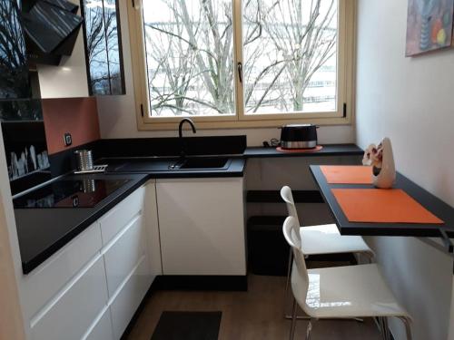 małą kuchnię ze stołem i oknem w obiekcie Bel appartement centre Rouen avec terrasse w Rouen