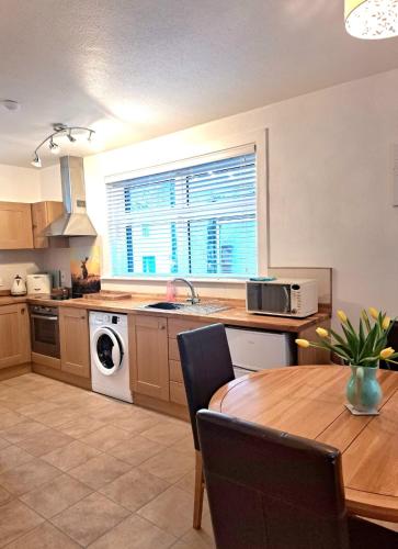 a kitchen with a table and a sink and a stove at Old Tavern House in Fortrose