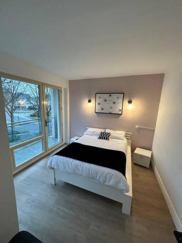 une chambre avec un lit et une grande fenêtre dans l'établissement Bel appartement centre Rouen avec terrasse, à Rouen