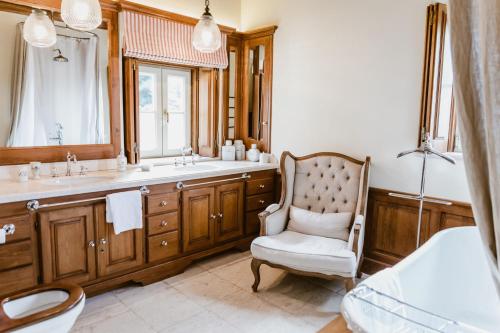 y baño con silla, lavabo y espejo. en Quinta da Bella Vista - Historic Home and Farm, en Sintra