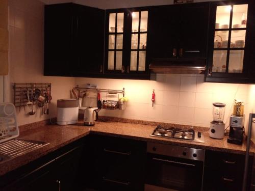 a kitchen with black cabinets and a counter top at Dar Rimayssa in Temara