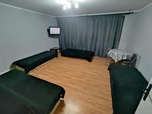 a living room with two beds and a table at 3030 Jana Spychalskiego 32 - Tanie Pokoje w Apartamencie - samodzielne zameldowanie - self check in in Poznań
