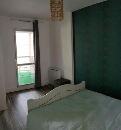 a bedroom with a bed with a green wall at APPARTEMENT AVEC TERRASSE SUR LE PORT in Fécamp
