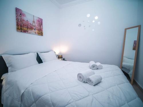 Un dormitorio con una cama blanca con toallas. en Angie's House Volos, en Volos
