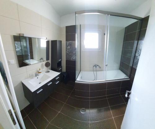 ein Bad mit einer Badewanne, einem Waschbecken und einer Dusche in der Unterkunft Marianna's House in Ýpsos