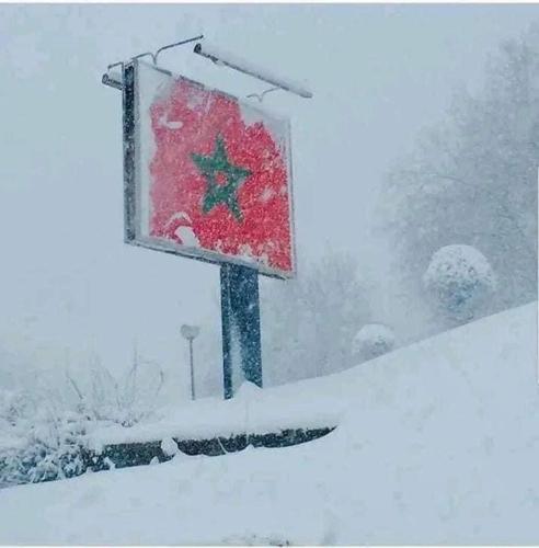 a snow storm with a red sign in the snow at Ifrane marhaba in Ifrane