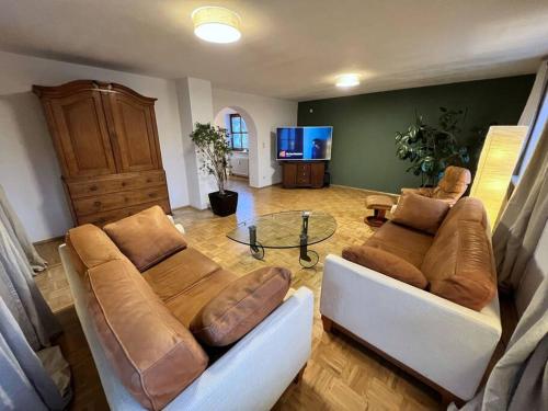 a living room with a couch and a glass table at Garten-Ferienwohnung Seppi in Tutzing
