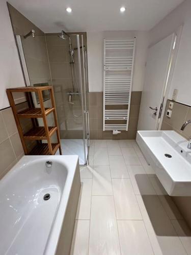 a white bathroom with two sinks and a shower at Garten-Ferienwohnung Seppi in Tutzing