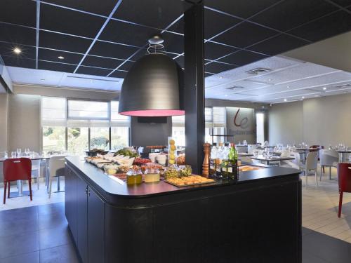 Un desayuno buffet en un restaurante con mesas y sillas. en Campanile Lyon Nord - Ecully, en Écully