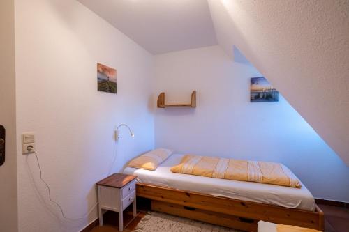 ヴィーク・アウフ・フェールにあるFerienwohnung Brittaの青い壁のドミトリールームのベッド1台分です。