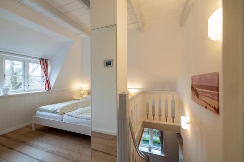 um pequeno quarto com uma cama e uma janela em Ferienwohnung Oldsum em Oldsum