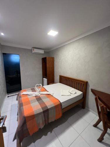 a bedroom with a bed with a blanket on it at Suítes&Flats MarBello in Maragogi