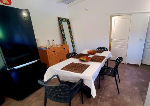 een keuken met een tafel en stoelen en een koelkast bij Saint Rose : Charmant T3 proche de la plage in Plessis-Nogent