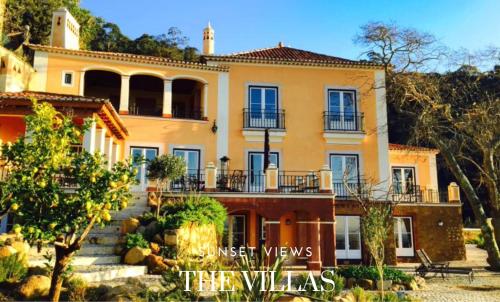 a large yellow house with stairs in front of it at Quinta da Bella Vista - Historic Home and Farm in Sintra