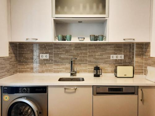 a kitchen with a sink and a washing machine at Ertem Apart in Datca