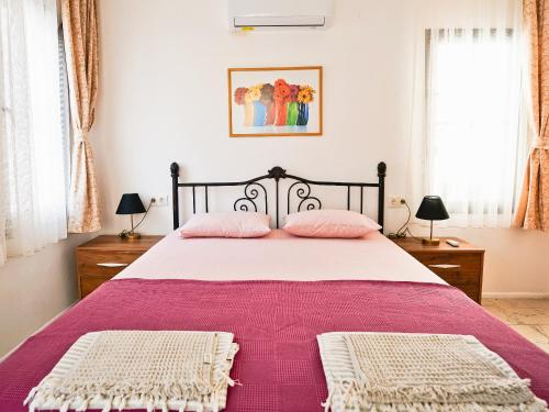 a bedroom with a large bed with pink blankets at Ertem Apart in Datca