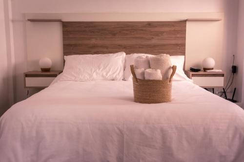 una cesta de toallas en la cama en undiano apart en Bahía Blanca
