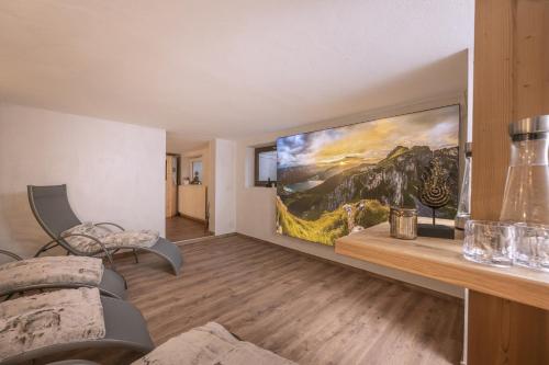 a living room with a large painting on the wall at Hotel Acherl in Achenkirch