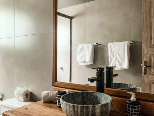 a bathroom with a sink and a mirror at Fazenda do Rosa in Praia do Rosa